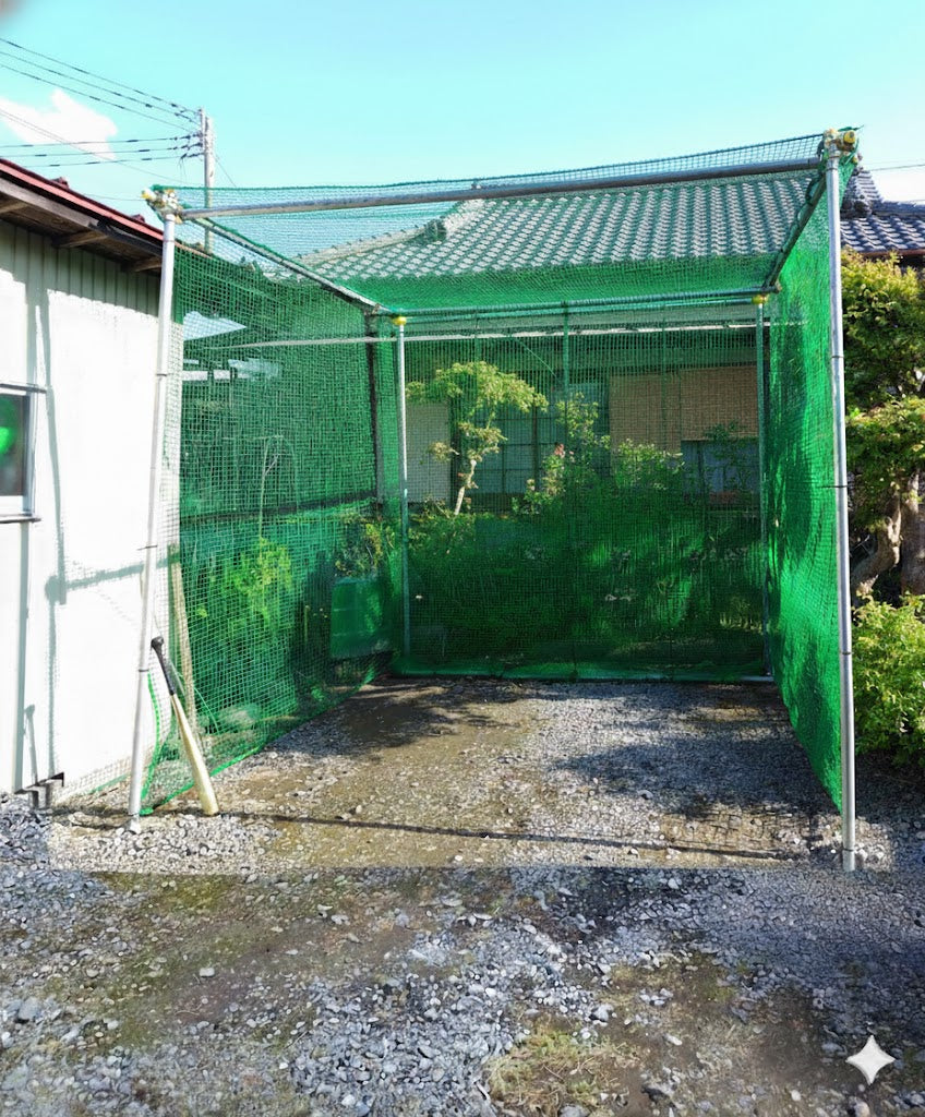 自宅の庭に単管パイプと杭（くい丸）を使って自作された、3m×3m×3mサイズの本格的なバッティングケージの全体写真。大人3名、週末2日間で組み立てられた施工事例。